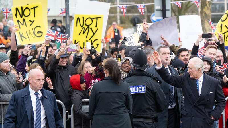 Charles comes face-to-face with protestors holding signs saying 