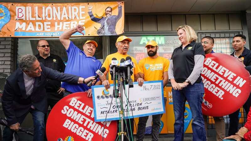 Business owner Joe Chahayed holds a check outside Joe