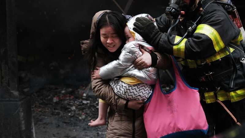 Woman with child in arms flees from mega New York fire