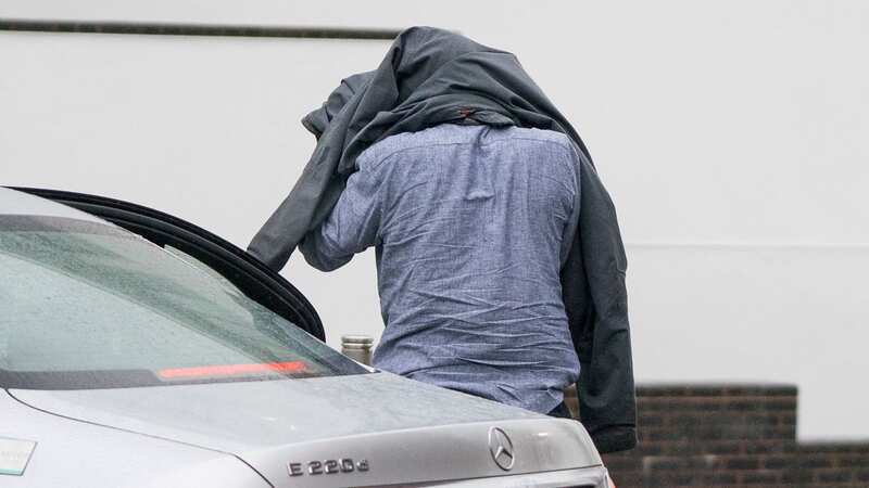 Timothy Schofield has been photographed covering his head with a jacket