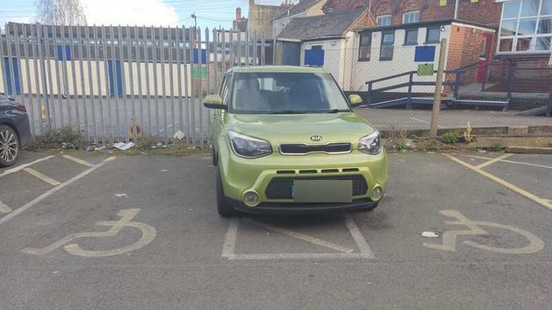 The lime green Kia was pictured hogging two spaces in the gap (Image: Facebook)