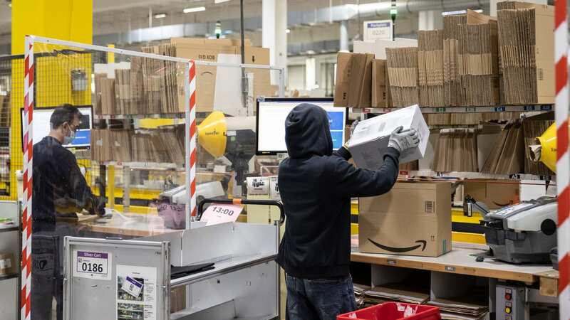 A worker packs items while fulfilling orders at an Amazon warehouse (Image: Getty Images)