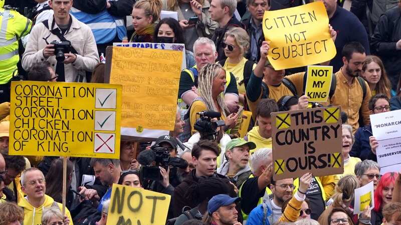 Protesters holding up placards saying 