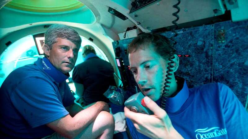 Submersible pilot Randy Holt, right, communicates with the support boat as he and Stockton Rush, left, CEO and Co-Founder of OceanGate, dive in the company