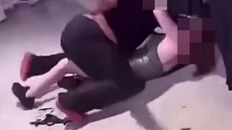 Onlookers stood-by and filmed as two women traded blows and rolled around on the shop floor in Birmingham
