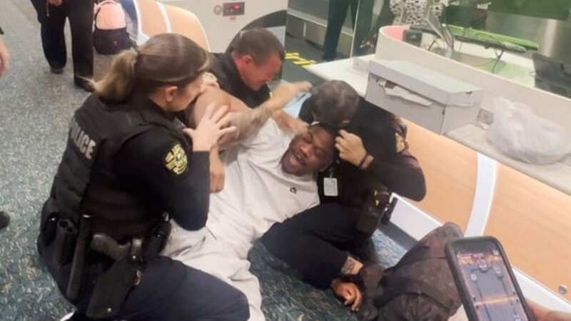 Man pinned down by four police officers after brawl over cancelled flight