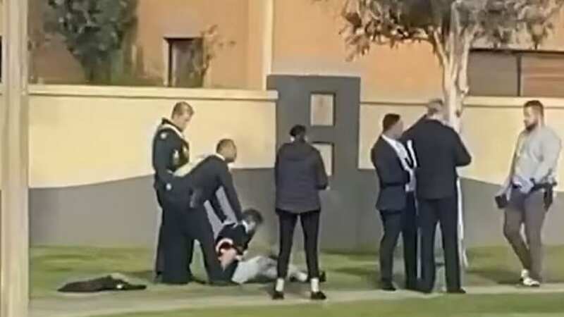 Cops hold down a man - whose trousers were reportedly stained with blood
