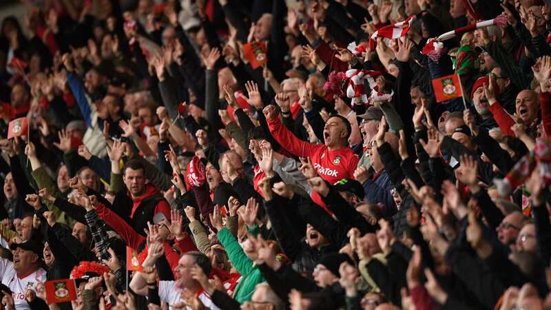 Wrexham fans celebrate their first goal during the English National League football match between Wrexham and Boreham Wood at the Racecourse Ground Stadium in Wrexham, north Wales, on April 22, 2023. (Photo by Oli SCARFF / AFP) (Photo by OLI SCARFF/AFP via Getty Images)
