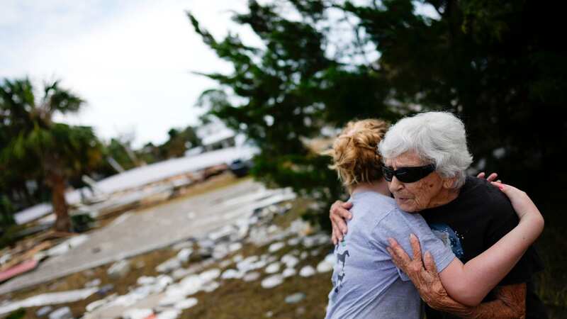 Tina Brotherton, 88, gets a hug from 9-year-old neighbour Lainey Hamelink, as she returns to site of her business, Tina