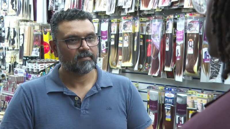 Shopkeeper says he regrets seizing woman by the throat amid huge protest