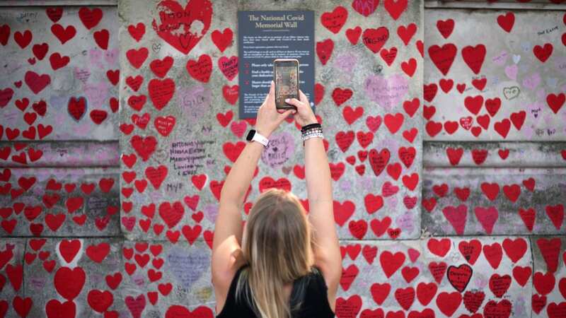 The National Covid Memorial Wall, dedicated to those who lost their lives to the virus, stands on the embankment on the south side of the River Thames (Image: AFP via Getty Images)