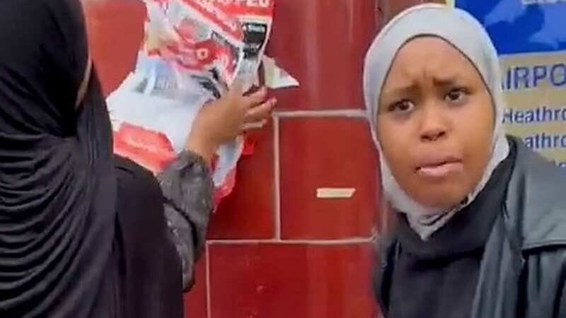 Two women were filming tearing down the posters put outside a London Underground station (Image: Twitter)