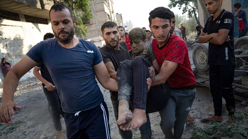 Palestinians carry a person wounded in Israeli airstrikes in Khan Younis, Gaza Strip (Image: AP)
