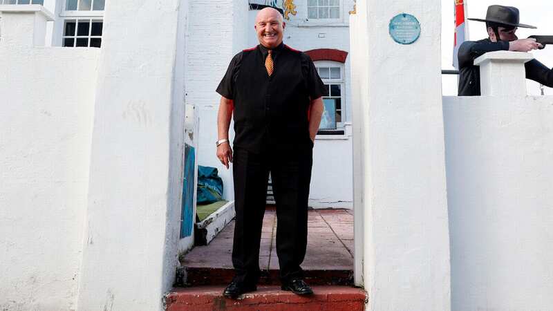 David Courtney poses for photos outside his house 