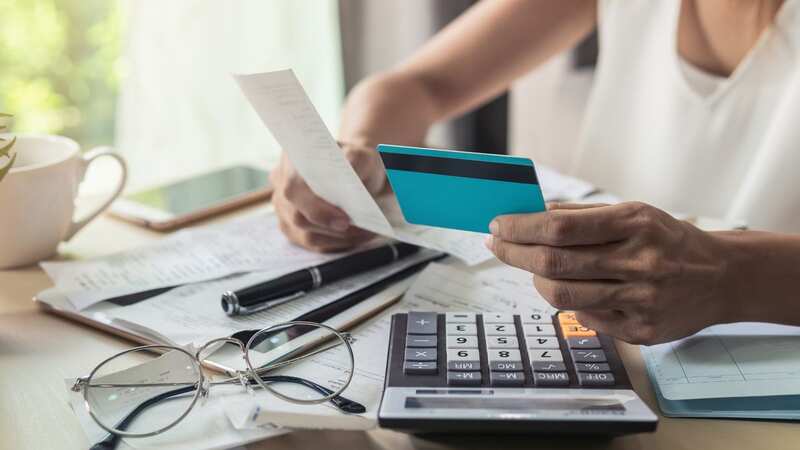 Young woman checking bills with a calculator (Image: Getty Images/EyeEm)