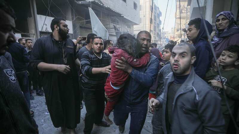 A Palestinian man carries an injured child following the resumption of Israeli bombing raids on houses in Rafah in southern Gaza (Image: Ismael Mohamad/UPI/REX/Shutterstock)