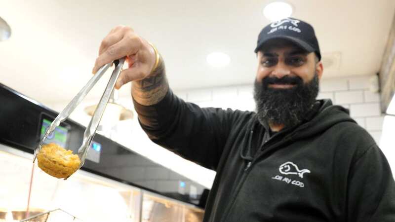 Bill Rai, who owns Oh My Cod, in Spalding, Lincs., with one of his Christmas specials: a battered mince pie (Image: Spalding Guardian / SWNS)