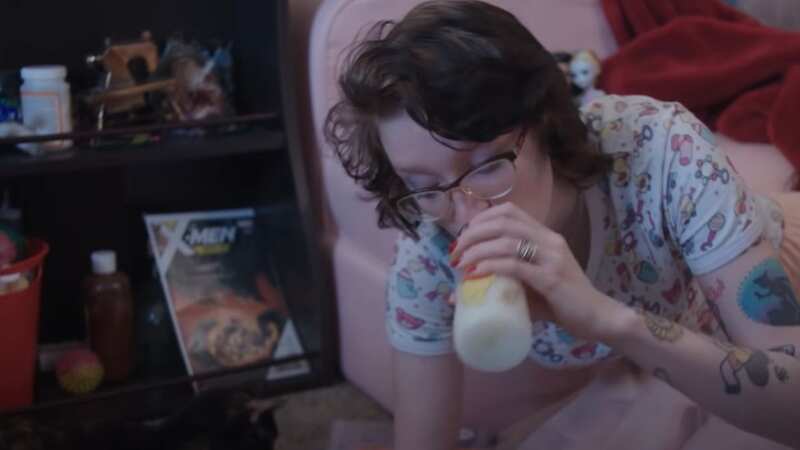 Adult toddler Max sucks on her bottle