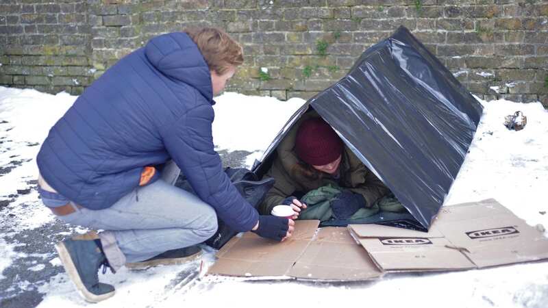 Rough sleeper in pod is handed a hot drink (Image: Ferrari Press Agency)