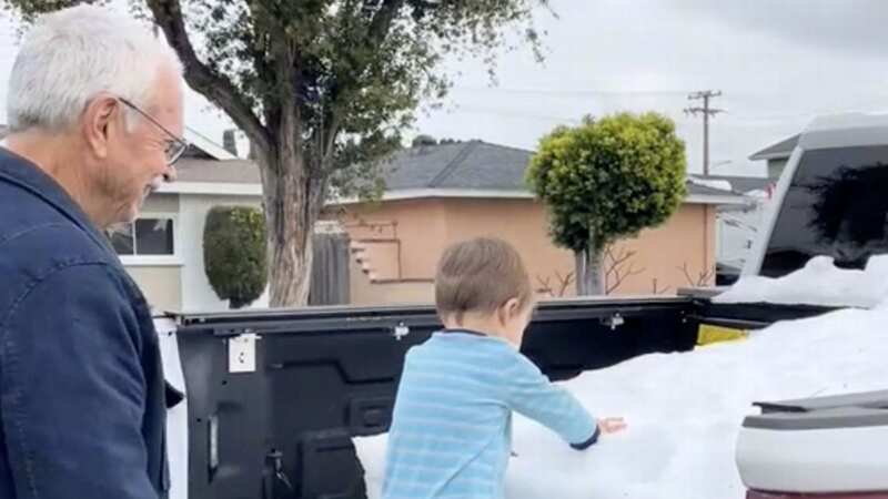 Grandpa Russ Furse shows his great-grandson Carter snow for the first time (Image: Collab / SWNS)