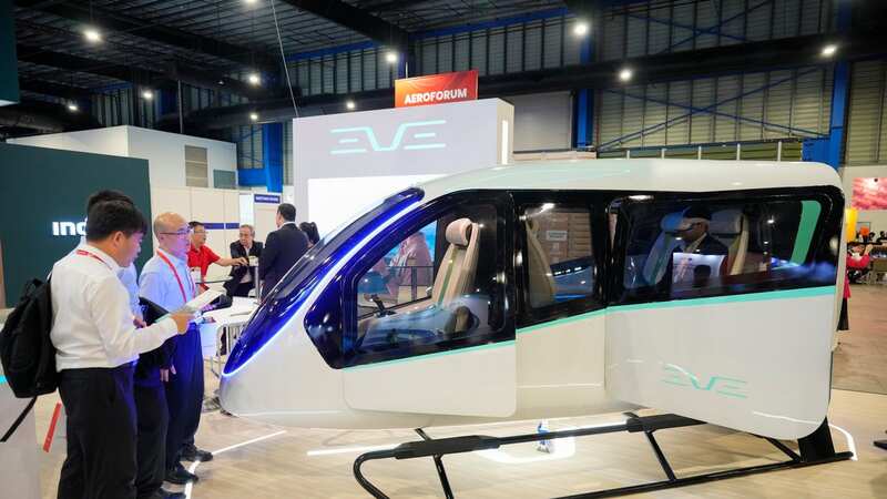 Visitors look at Brazilian firm Eve Air Mobility, a spin-off by third largest aircraft manufacturer Embraer (AP Photo/Vincent Thian) (Image: Copyright 2024 The Associated Press. All rights reserved)