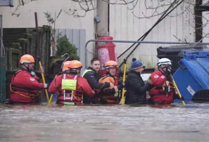 People are escorted through flood waters in Enniscorthy, Co. Wexford. Picture: Alamy