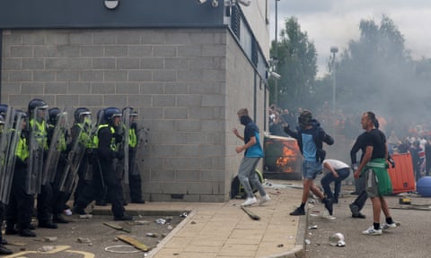 Riot police face rioters as fire burns in background dqxikeidqkikdinv