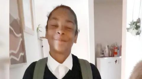 Mary Bokassa Kelyan Bokassa, a black boy in school uniform, chest upwards dqxikeidqkikdinv