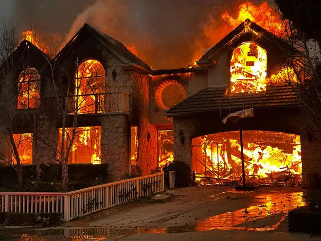 The Palisades Fire burns a structure in the Pacific Palisades neighborhood of Los Angeles, Wednesday, Jan. 8, 2025. (AP Photo/Eugene Garcia) dqxikeidqkikdinv