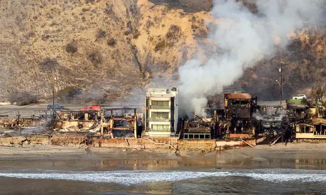 In this aerial view taken from a helicopter, burned homes are seen from above during the Palisades fire in Malibu, Los Angeles county, California dqxikeidqkikdinv
