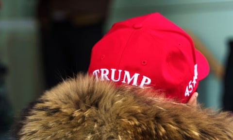A person photographed from behind is wearing a Maga hat with &lsquo;Trump&rsquo; written across the back