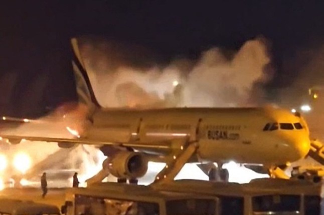 Fire authorities work to extinguish a fire that broke out on an Air Busan passenger plane at Gimhae International Airport in Busan on January 28, 2025. The tail of a passenger aircraft caught fire at an international airport in South Korea’s second-largest city on January 28, forcing the evacuation of 176 people on board, Yonhap news agency reported. (Photo by YONHAP / AFP) / - South Korea OUT / NO ARCHIVES - RESTRICTED TO SUBSCRIPTION USE (Photo by -/YONHAP/AFP via Getty Images) dqxikeidqkikdinv