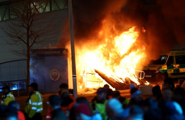 MANCHESTER, ENGLAND - JANUARY 29: A general view as a merchandise stall on the outside of the stadium is seen on fire as fans gather outside the stadium prior to the UEFA Champions League 2024/25 League Phase MD8 match between Manchester City and Club Brugge KV at City of Manchester Stadium on January 29, 2025 in Manchester, England. (Photo by Carl Recine/Getty Images) dqxikeidqkikdinv