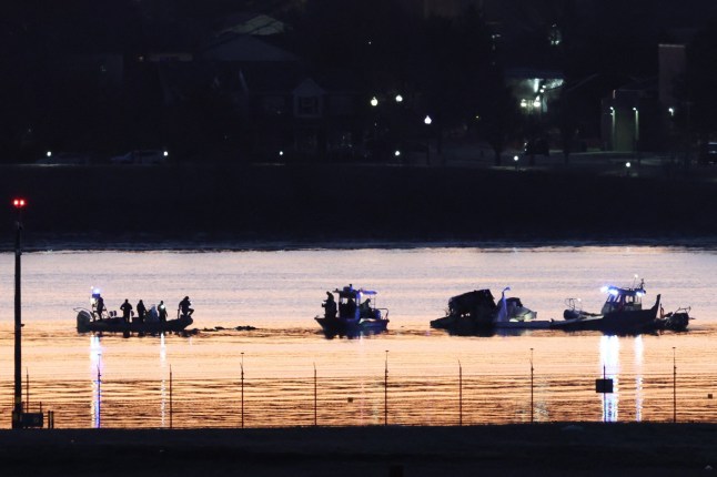 Rescuers on a boat work, as the sun rises, at the site of the crash after a Black Hawk helicopter collided with the American Eagle flight 5342, which was approaching Reagan Washington National Airport, and crashed into the Potomac River, outside Washington, U.S., January 30, 2025. REUTERS/Kevin Lamarque dqxikeidqkikdinv