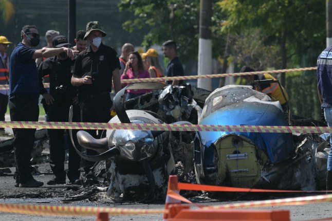 Police investigadors work at the site of a plane accident in Sao Paulo, Brazil, on February 7, 2025. A plane plunged into a major avenue in the Brazilian city of Sao Paulo on Friday and exploded after hitting a bus, leaving two people dead and six injured, officials said. (Photo by NELSON ALMEIDA / AFP) (Photo by NELSON ALMEIDA/AFP via Getty Images) dqxikeidqkikdinv