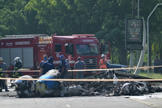Members of Brazil&rsquo;s Aviation Accident Investigation and Prevention Center (CENIPA) and firefighters work at the site of a plane accident in Sao Paulo, Brazil, on February 7, 2025. A plane plunged into a major avenue in the Brazilian city of Sao Paulo on Friday and exploded after hitting a bus, leaving two people dead and six injured, officials said. (Photo by NELSON ALMEIDA / AFP) (Photo by NELSON ALMEIDA/AFP via Getty Images)