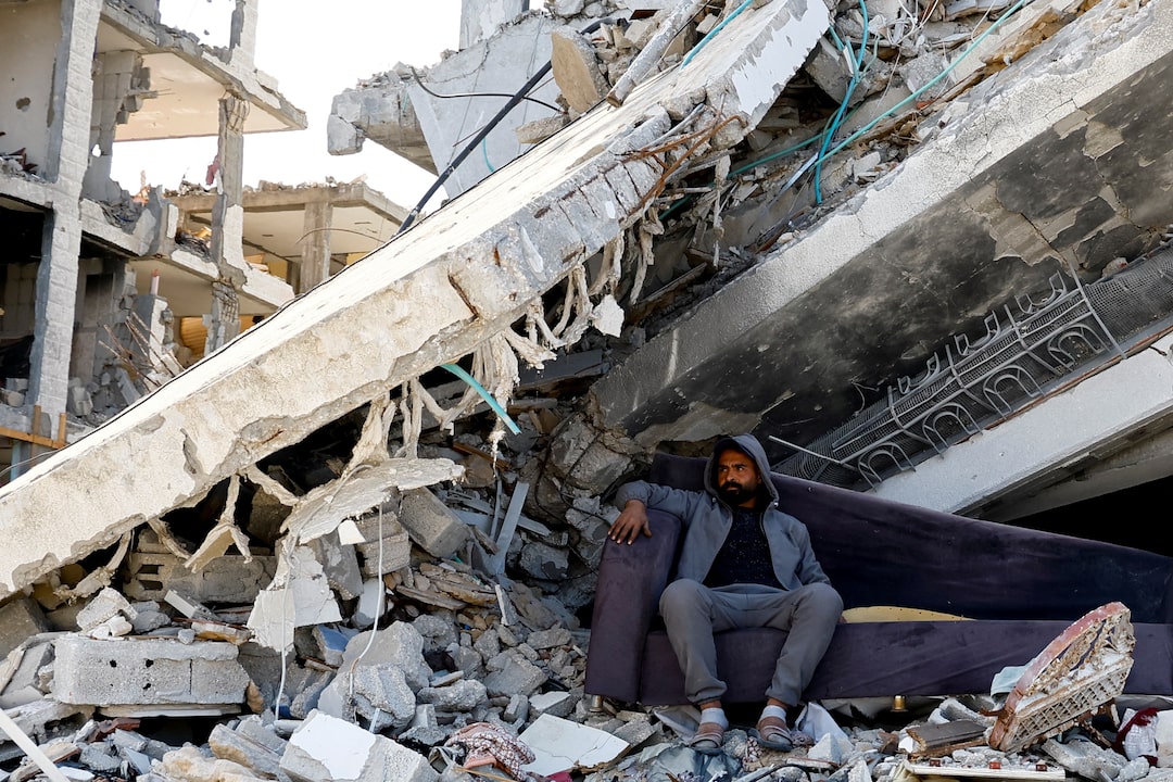 A Palestinian man sits amidst the rubble of buildings destroyed during the Israeli offensive, amid a ceasefire between Israel and Hamas, in Rafah dqxikeidqkikdinv