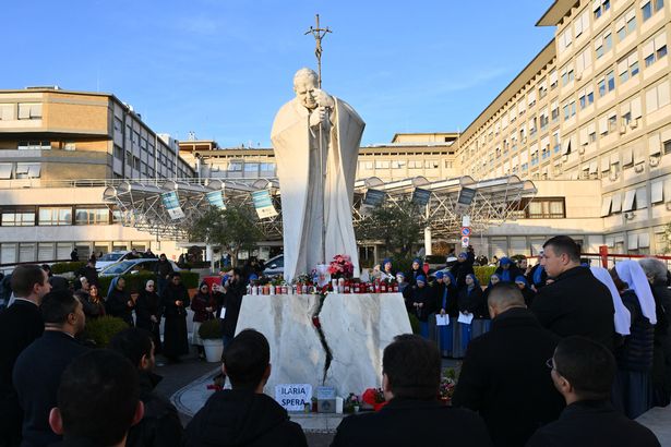 People pray at the statue of John Paul II outside the Gemelli hospital dqxikeidqkikdinv