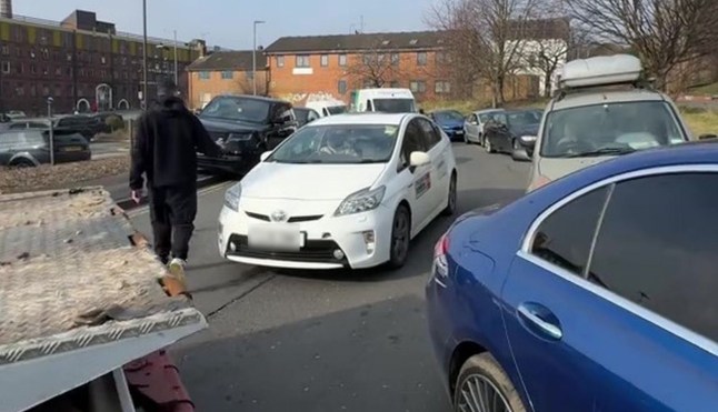 PIC FROM KENNEDY NEWS AND MEDIA (PICTURED: ROB KELLY, 31, OUTSIDE VERTU LAND ROVER LEEDS THE DAY HE BLOCKED THE ROAD) A furious Land Rover driver BLOCKED a dealership in a six-hour stand-off - after being refused warranty repairs on ?120,000 motor. Rob Kelly abandoned his lorry in the road outside Vertu Land Rover Leeds in Leeds, West Yorkshire, on February 18th and refused to shift it until free engine repairs were done to his car. The 31-year-old claims he&rsquo;d been in touch with the dealership a number of times after his 2022 Urban Defender broke down in January. DISCLAIMER: While Kennedy News and Media uses its best endeavours to establish the copyright and authenticity of all pictures supplied, it accepts no liability for any damage, loss or legal action caused by the use of images supplied and the publication of images is solely at your discretion. SEE KENNEDY NEWS COPY - 0161 697 4266 dqxikeidqkikdinv