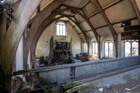 Urbandoned A raised gallery inside a church. The floorboards appear rotten and are covered with dirt